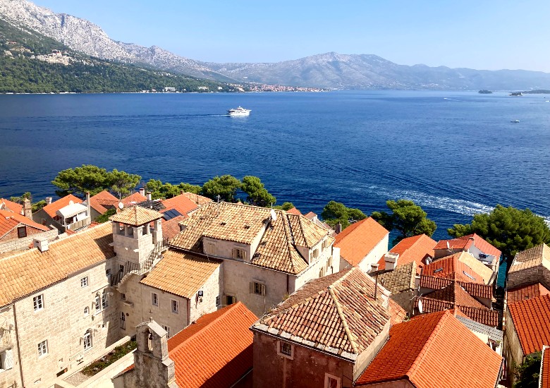 Terracotta roofs of Korcula old town buildings with view out to the sea