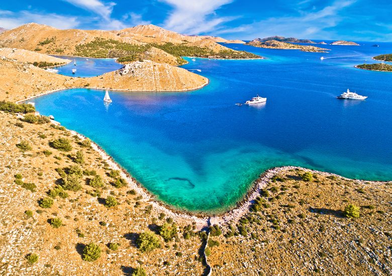 Barren island landscapes of the Kornati archipelago with turquoise water and sailing boats