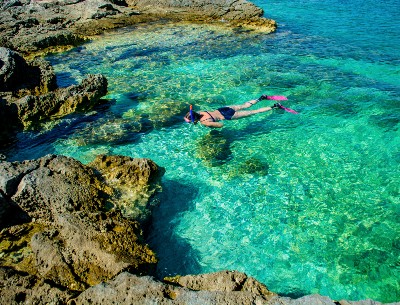 A woman snorkeling in turquoise water of Croatia