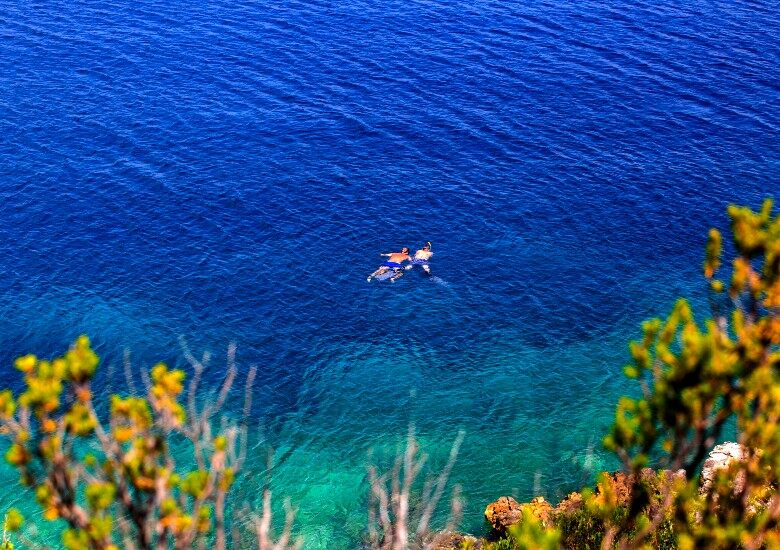 Two people snorkeling in a turquoise sea